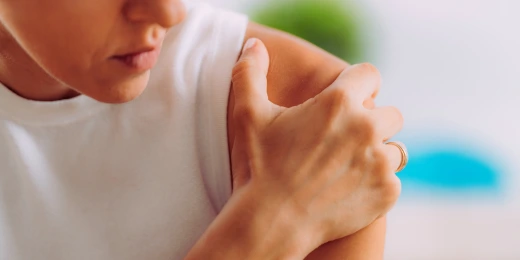 Woman holding her shoulder in pain with common shoulder injuries from a car accident that a chiropractor can help with in Hiram, Georgia.