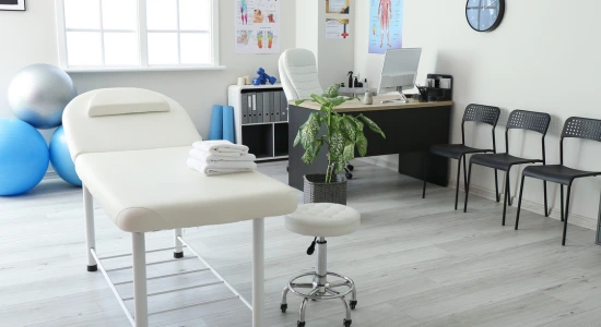 Chiropractor's office featuring a medical table, chairs, a desk, and a plant - can a chiropractor prescribe medication in Hiram, GA.